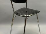 une chaise en métal avec une assise noire sur fond blanc