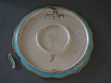 a blue and white plate with a gold rim on a table