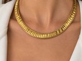une femme portant un collier et des boucles d'oreilles en or