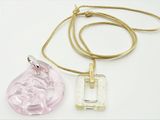 pendentif en verre rose et transparent, muni d'une chaîne en or, sur fond blanc