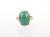 a close up of a green jade ring on a white surface