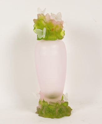 un vase rose contenant des fleurs, posé sur une surface blanche