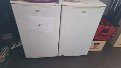 two refrigerators sitting next to each other in a room
