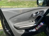 a car door with the door handle open and a bottle of soda in it