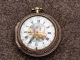 un gros plan d'une montre de poche ornée de chiffres romains