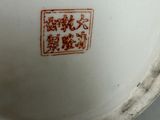a white bowl with a red design on the inside of it