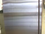 a stainless steel refrigerator sitting in a warehouse