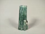 a close up of a green piece of rock on a white surface