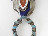 an image of a silver and blue broochle with a ribbon around it