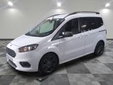 la camionnette blanche est garée sur le sol en damier d'un garage