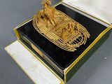 a small box with a gold figurine inside of it