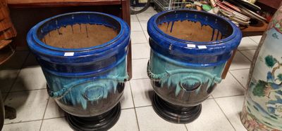 deux vases bleus posés par terre l'un à côté de l'autre
