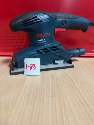 une ponceuse orbitale Black & Decker posée sur une table en bois