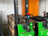 deux chariots élévateurs verts et noirs dans un entrepôt