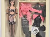 une poupée Barbie dans une boîte contenant des vêtements et des accessoires