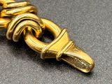 a close up of a gold chain with a knot on it