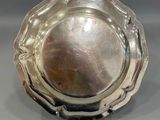 an antique silver plate with a decorative design on it