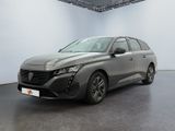 Une voiture grise est garée dans une pièce blanche au sol noir.