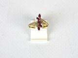 un gros plan d'une bague en or ornée d'une fleur rouge