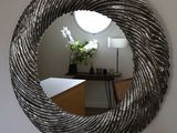 a round mirror hanging on the wall in a room