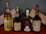 Plusieurs bouteilles d'alcool sont alignées sur une table rouge
