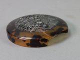 a small tortoise shell with a silver eagle on it