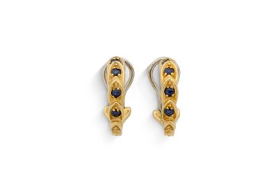 une paire de boucles d'oreilles en or ornées de saphirs sur fond blanc