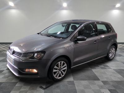 une Volkswagen Polo break grise garée dans une pièce au sol carrelé