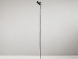 un lampadaire noir posé sur une surface blanche, avec un fond blanc