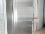 a stainless steel refrigerator in the middle of a kitchen