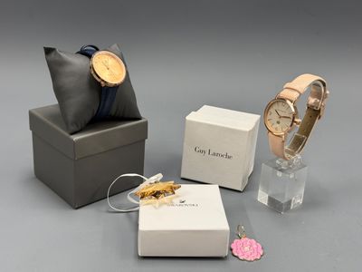 Deux montres, un bracelet et une bague sont posés sur une table