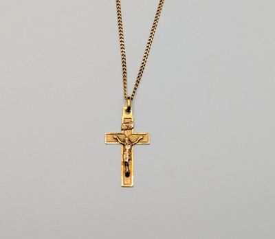 un pendentif en forme de croix en or, orné d'une pierre noire, monté sur une chaîne en or