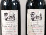 two bottles of red wine sitting next to each other on a table