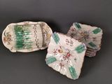 three pieces of porcelain dishes with floral designs on them on a gray surface