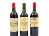 trois bouteilles de vin rouge sont posées côte à côte sur une surface blanche