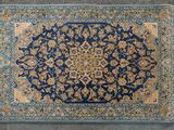 un gros plan sur un tapis bleu orné d'un motif en médaillon