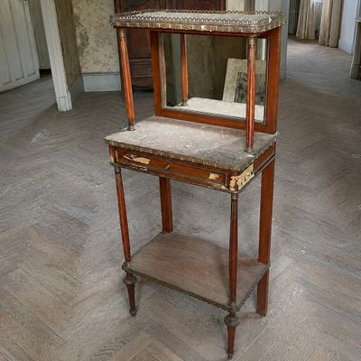 une petite table sur laquelle est posé un miroir, au milieu d'une pièce
