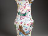 un vase blanc orné de motifs colorés sur un fond gris