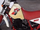 a red and white dirt bike parked in a garage