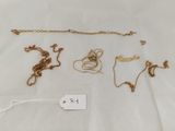 a group of gold necklaces and bracelets on a white surface