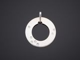 un pendentif plaqué argent présentant un motif circulaire sur fond noir