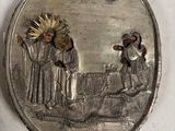 une image représentant une assiette en argent sur laquelle figurent un homme et une femme