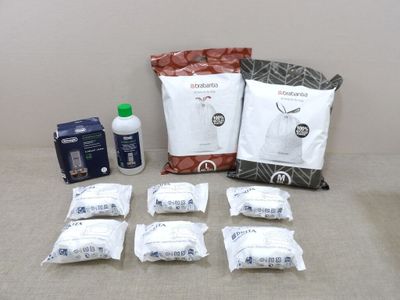several bags of food are sitting on a table next to a bottle of water
