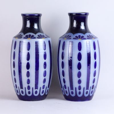 pair of blue and white vases sitting on a white surface