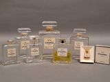 cinq flacons de parfum posés à côté d'une boîte d'allumettes