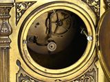 a gold clock that is sitting on a table