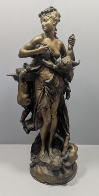 statue en bronze d'une femme tenant un oiseau sur un piédestal