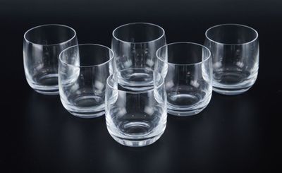 six empty glasses are lined up on a black surface