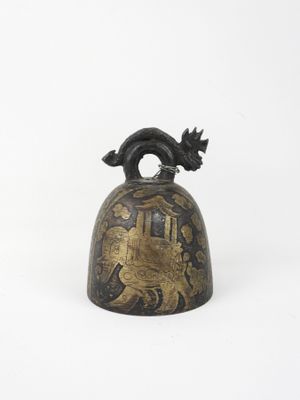 an old bell with a bird on it sitting on a white surface