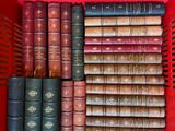 many old books in a red basket on the shelf